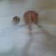 A Girl Socking on the bathing tub with full of water