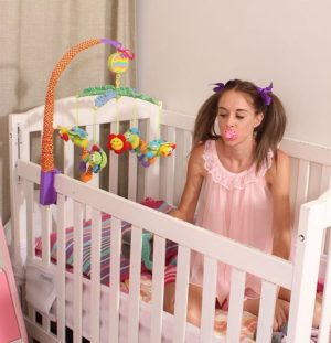 A adult Girl Sitting inside her cot along with sucking pacifier