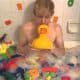 Teen boy play with toys and soap on the belly in the bath water