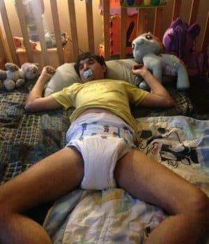 Adult Man Wearing the baby diaper and lying on the bed