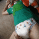 Adult Man In Diaper Holding Teddy While Lying On The floor