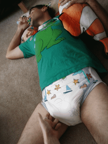 Adult Man In Diaper Holding Teddy While Lying On The floor