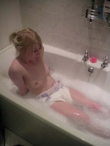 Small girl bathing with foam in a bathtub