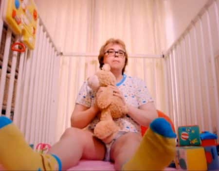 Old granny As Baby Child In Diaper With Teddy Bear
