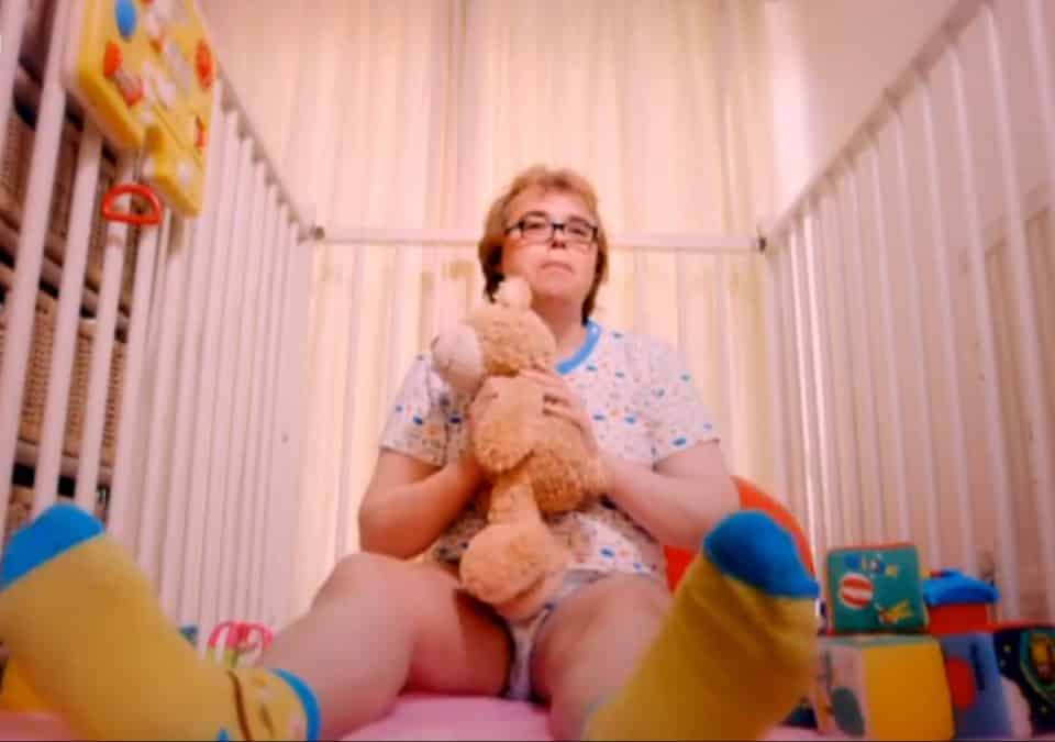 Old granny As Baby Child In Diaper With Teddy Bear