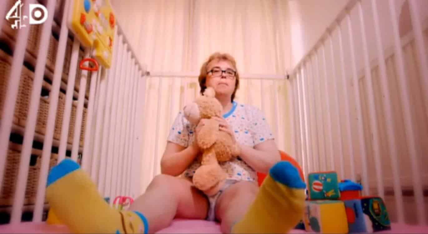 Old granny As Baby Child In Diaper With Teddy Bear