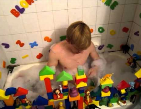 Adult teen baby bathing on the bath tub while playing puzzle