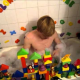 Adult teen baby bathing on the bath tub while playing puzzle