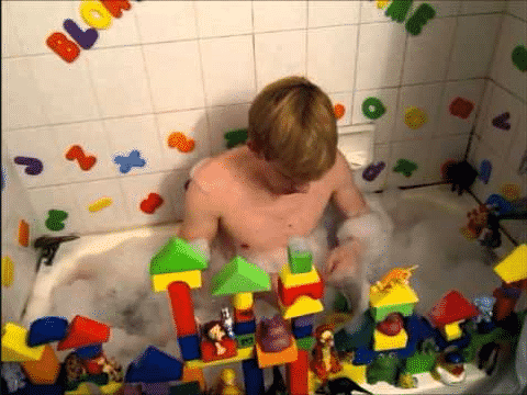 Adult teen baby bathing on the bath tub while playing puzzle