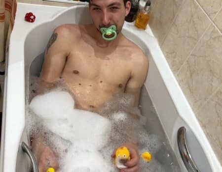 Naked Man bathing in bathtub and filled with soap