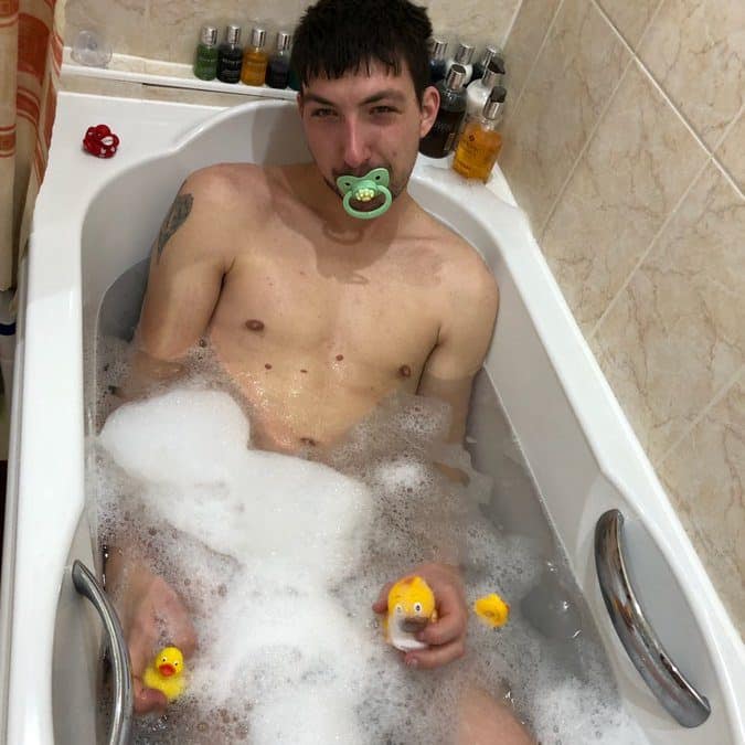 Naked Man bathing in bathtub and filled with soap