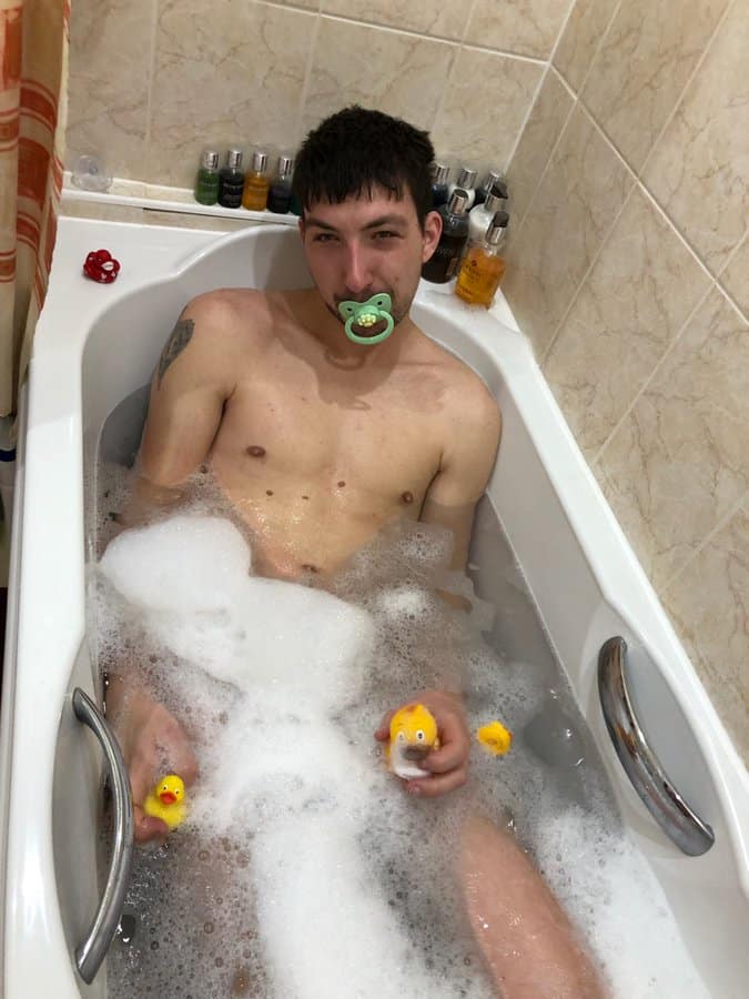 Naked Man bathing in bathtub and filled with soap