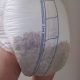 A boy wearing the dirty wet diaper with standing