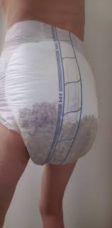 A boy wearing the dirty wet diaper with standing