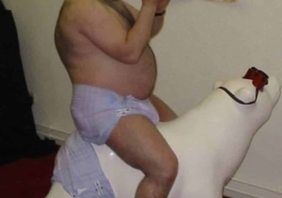 Old Man Sucking the feeding bottle and sitiing on the polar bear